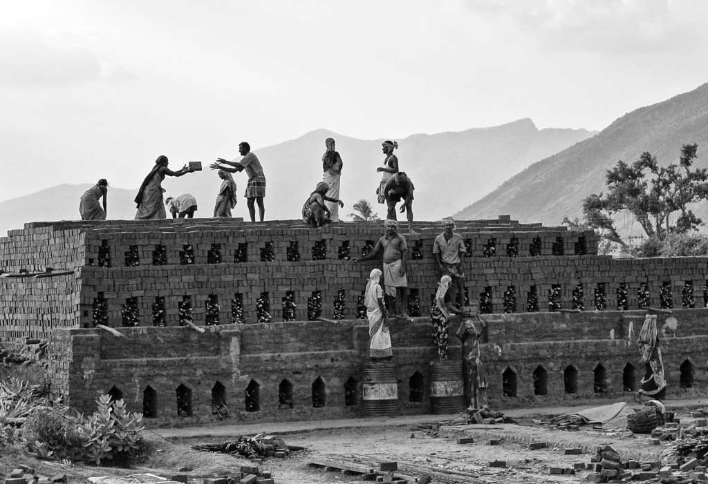 Workers, both men and women, working in a brick kiln, Near T. Kallupatti, Tamil Nadu, India.