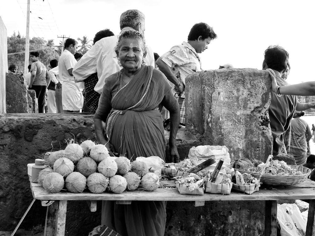 An old woman selling things like coconuts, flowers and incense sticks for puja and rites. Rameshwaram, Tamil Nadu, India