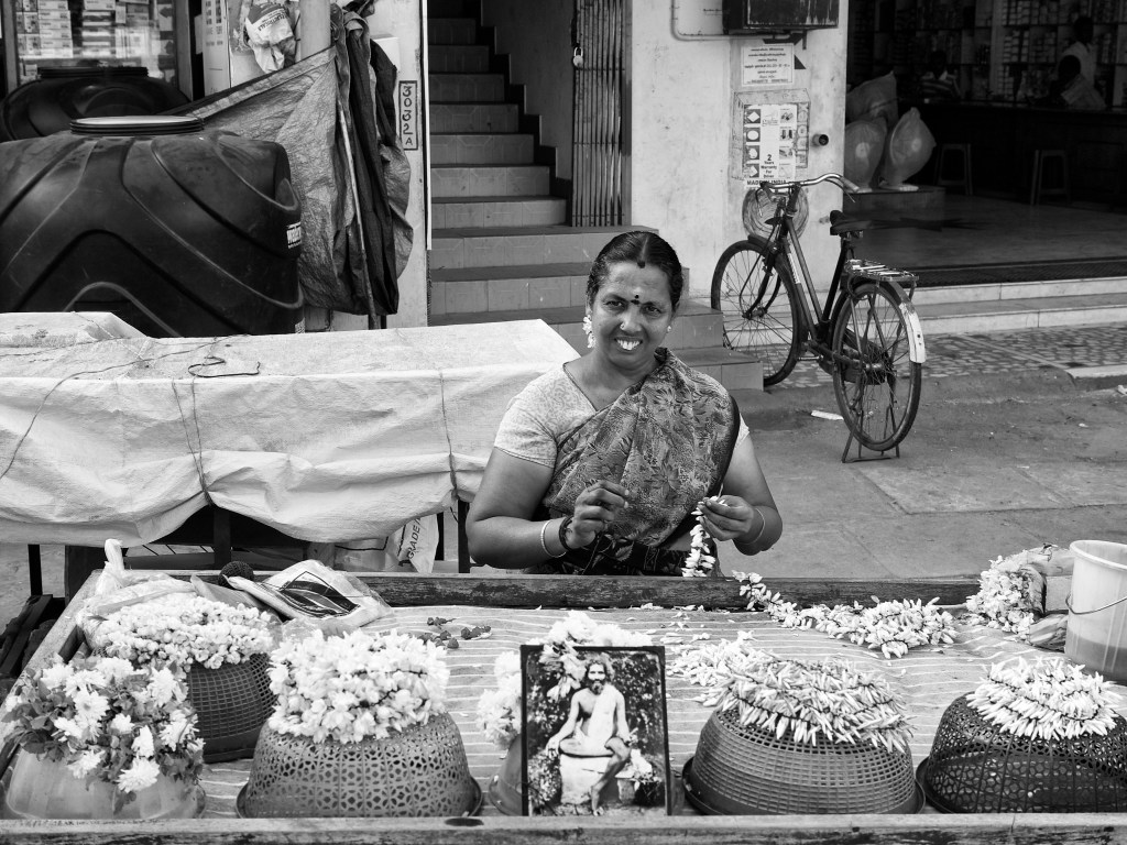 A woman, flower seller, making garlands in her mobile cart, Thanjavur, Tamil Nadu, India