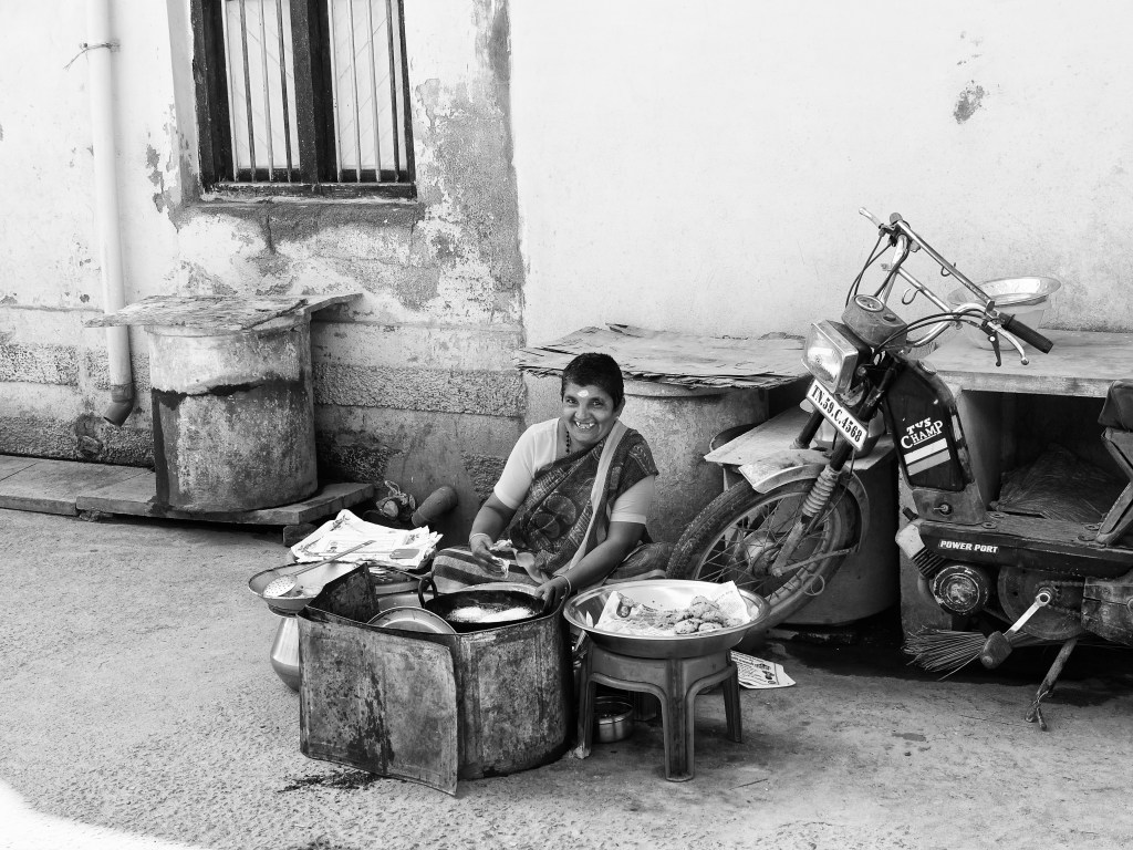 An old woman frying 'Vada' in her street-side food shop, Virudhunagar, Tamil Nadu, India