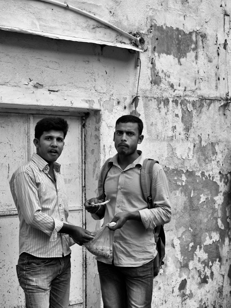 Two migrant Bangladeshi workers sharing a quick evening meal by the street side. Bangla Bazar, Singapore