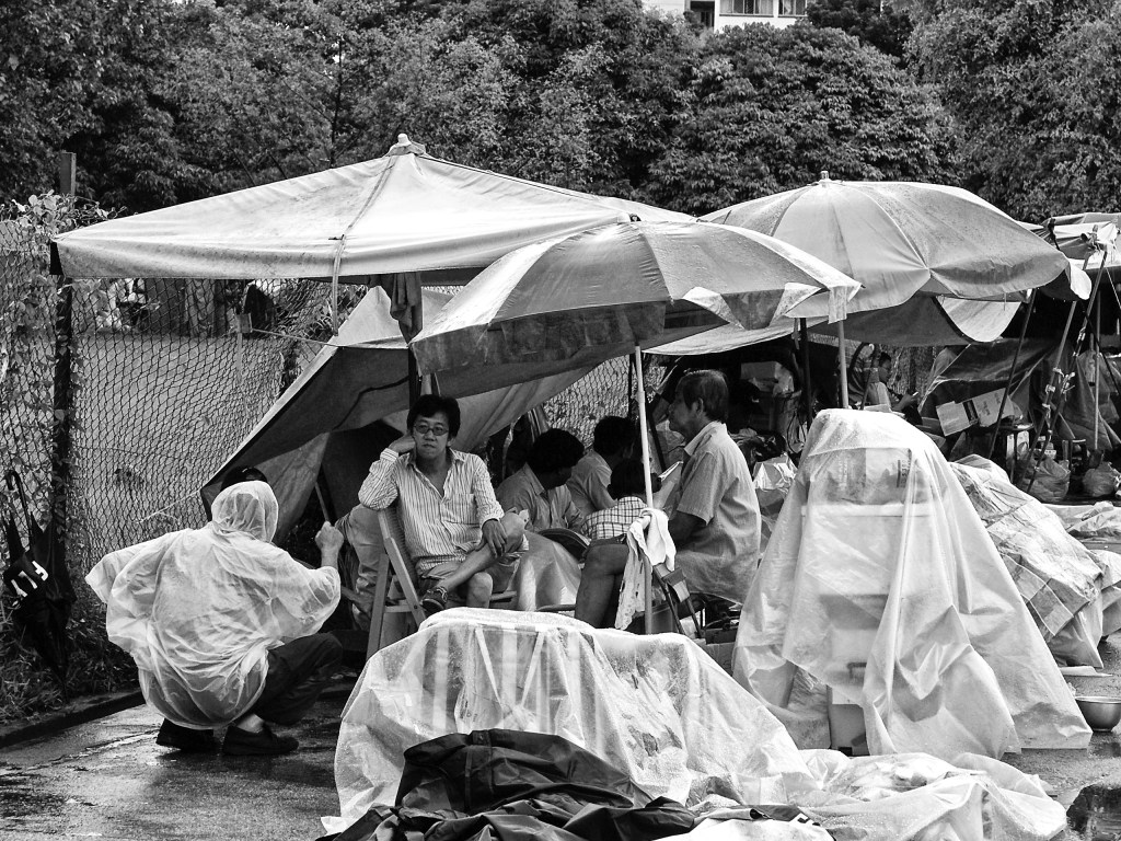 Street vendors are taking a break and at a conversation during a rain interruption, Jln Besar Flea Market, Pitt Street, Singapore