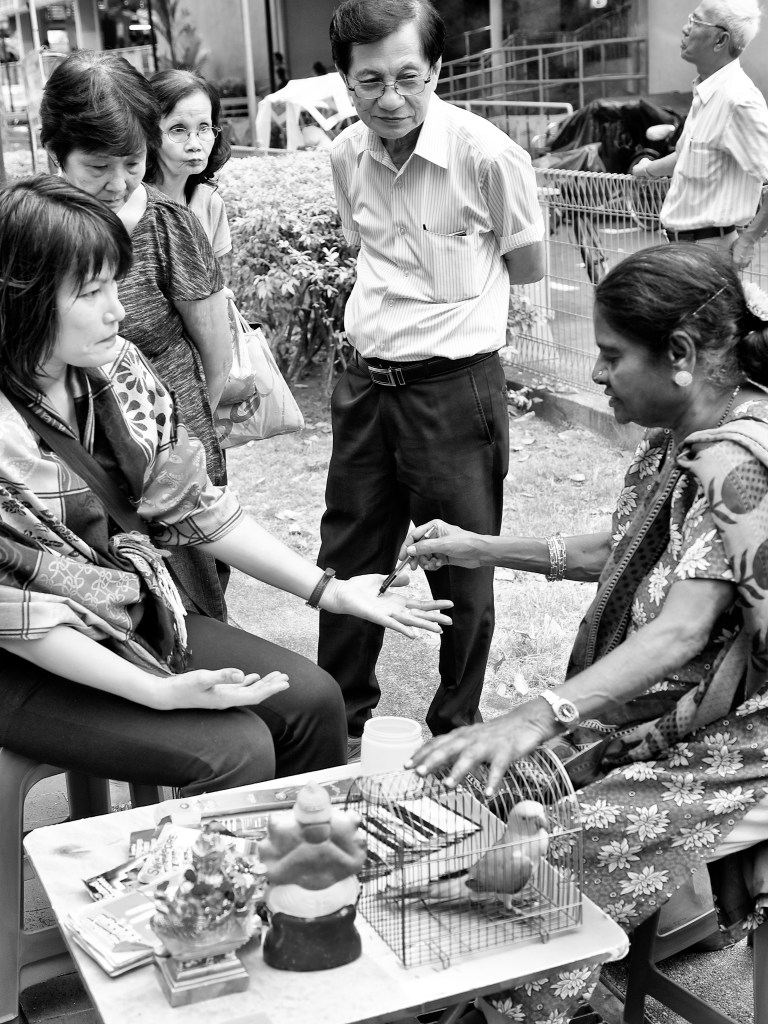 A woman parrot-astrologer counselling her client, Bugis, Singapore