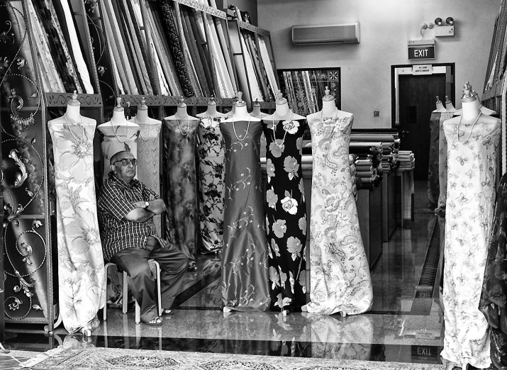 Textile shop owner in the company of his mannequins, Arab Street, Singapore
