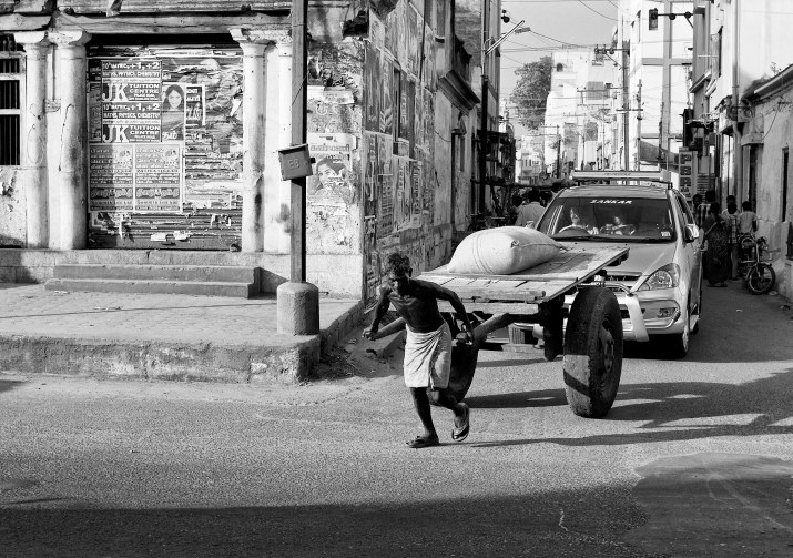A load(ing) man, taking the load in a pull-cart. Madurai, India. 